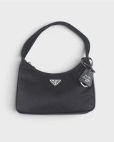 NEWSEDのPRADA Re-Edition 2000 Re-Nylonミニバッグ。ブラックのナイロン素材にアイコニックな三角ロゴプレートとチャームが付いたワンショルダーバッグ