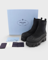 NEWSEDのPRADAモノリスRe-Nylonショートブーツ。ブラックのギャバジン素材に厚底ソールとトライアングルロゴが特徴的な未使用品。