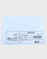 NEWSEDが販売するPRADAモノリスRe-Nylonブーツの製品情報が記載されたブラックのタグ