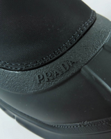 NEWSEDのPRADAモノリスRe-Nylonショートブーツ。ブラックのギャバジン素材にエンボスロゴが施されたディテール