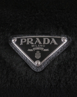 NEWSEDのPRADAシープファーバケットハット、ブラックの本体にアイコニックなトライアングルロゴプレートが施されたデザイン
