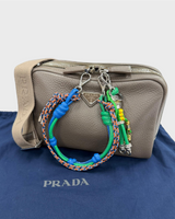 NEWSEDのPRADAヴィッテロダイノレザーショルダーバッグ。グレージュの本体にカラフルなトリックチャームが付属したトライアングルロゴ付きデザイン。