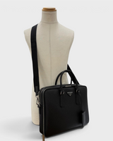 NEWSEDのPRADAブラックサフィアーノレザー製ビジネスバッグ。ショルダーストラップ付きの洗練されたメンズ用ブリーフケース。