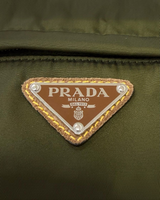NEWSEDのPRADAカーキ色Re-Nylonボディバッグに施されたアイコニックなトライアングルロゴのアップ