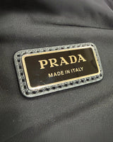NEWSEDで販売中のPRADA Re-Nylonショルダーバッグにあしらわれたアイコニックなブラックのトライアングルロゴプレート