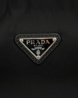 NEWSEDで販売中のPRADA Re-Edition 2005 Re-Nylonバッグの象徴的なブラックのトライアングルロゴプレート