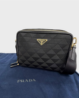 NEWSEDのPRADAブリックショルダーバッグ。ブラックのトライアングルジャガード生地にレザーのディテールとゴールドのロゴプレートが特徴。