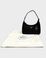 NEWSEDのPRADA Re-Edition 2000 Re-Nylonミニバッグ。ブラックのナイロン製でアイコニックな三角ロゴとチャーム付き。