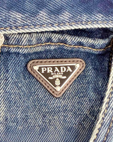 NEWSEDのPRADAデニムジャンプスーツに施されたアイコニックなトライアングルロゴプレートのクローズアップ