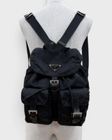 NEWSEDが販売するPRADAのブラックRe-Nylonスモールバックパック。トライアングルロゴとベルト金具が特徴的なレディースリュック