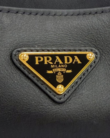 NEWSEDのPRADAソフトグレインレザーショルダーバッグにあしらわれたアイコニックなゴールドのトライアングルロゴ