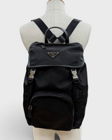 NEWSEDのPRADAブラックナイロンバックパック。フロントにアイコニックなトライアングルロゴプレートとレザーのトリミングが施されたメンズリュック。