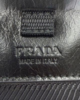 NEWSEDで販売中のPRADAのブラックレザー製スマートフォンケース。ロゴ刻印が施された高品質なソフトルックスレザーの質感。