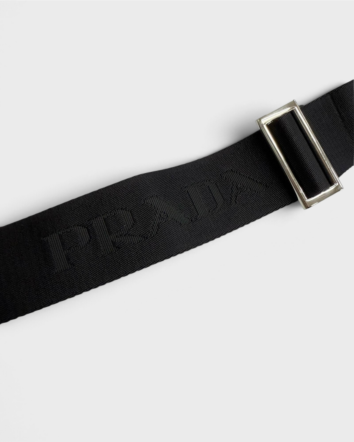 NEWSEDのPRADAブラックショルダーバッグのロゴ入りストラップとシルバー金具のディテール