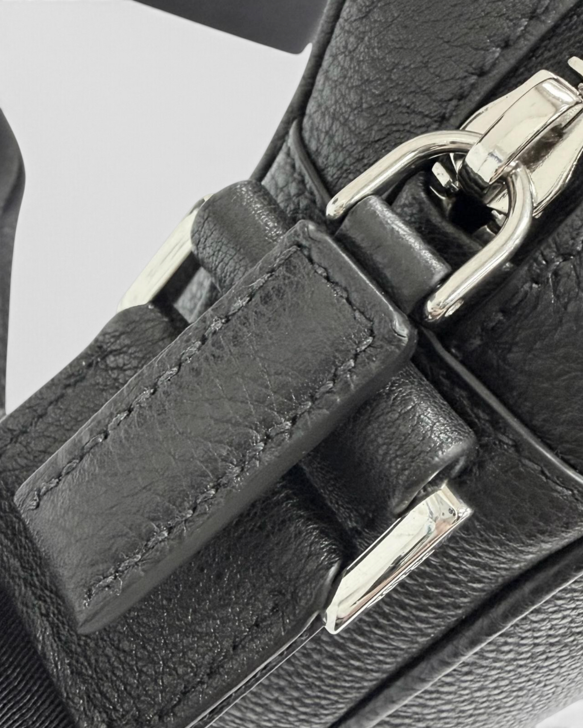 NEWSEDのPRADAブラックレザー製クロスボディバッグのファスナーと金具のクローズアップ