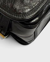 NEWSEDのPRADAブラックソフトルックスレザー製ショルダーバッグの側面とフラップ部分のクローズアップ