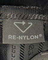 NEWSEDが販売するPRADAのRe-Nylonショルダーバッグの内部タグ。リサイクルナイロン素材を示すロゴが刺繍されている。