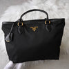 Prada 尼龙和 Saffiano 皮革托特包，带黑色和金色三角形徽标